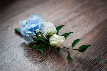 White with blue rose buttonhole on the tableの写真素材