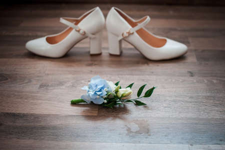 White with blue rose buttonhole and white high hill shoesの写真素材
