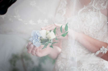 White with blue rose buttonhole in the girls hand
