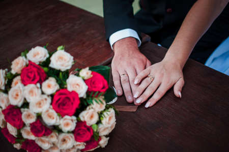 bride and groom in a cafe. wedding bouquet on a wooden table in a restaurantの写真素材