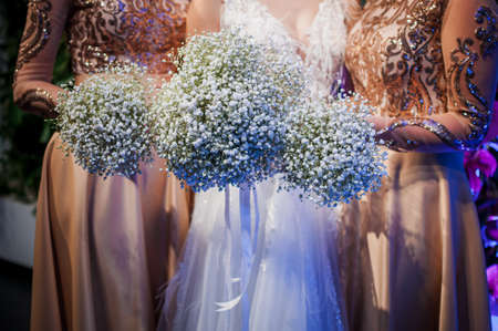 Girls holding white bouquets of flowers in the handsの写真素材