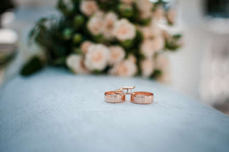 Gold wedding rings on the pink bouquet of flowers