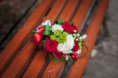 Red with white flower bouquet lies on a benchの写真素材
