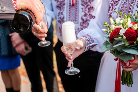 man pouring champagne in the wineglasses for his friendsの写真素材