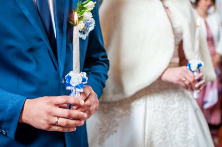 The groom and the bride with candles. Wedding ceremony in church