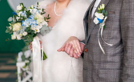 Groom and bride holding hands togetherの写真素材