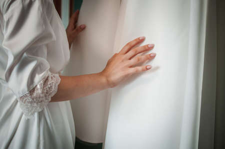 Bride puts hand on wedding dressの写真素材