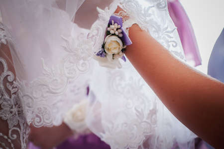 Bridesmaids assist bride to wear wedding dressの写真素材