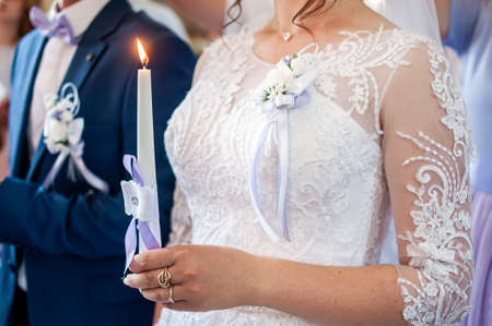 Bride holding candle in the hand