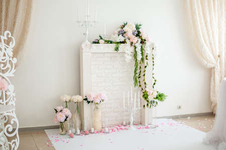White fireplace with candles and bouquet of flowersの写真素材