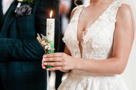 Bride and groom holding candles in the churchの写真素材