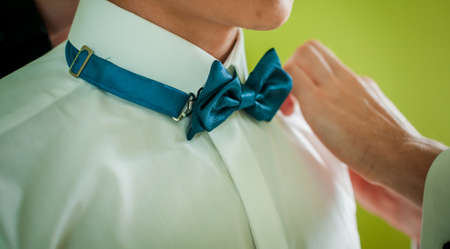 Groom hold green bowtie on the neckの写真素材