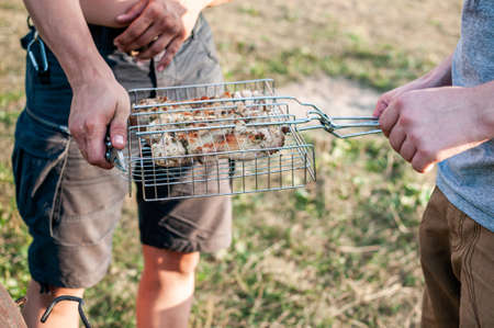 Man holding grid with meat for the barbequeの写真素材