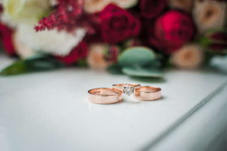 Pair of gold wedding rings and gold ring with gemの写真素材