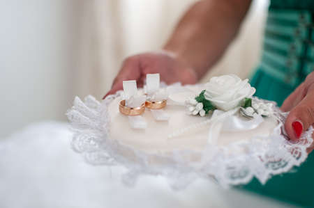 Couple of gold wedding rings on the white padの写真素材