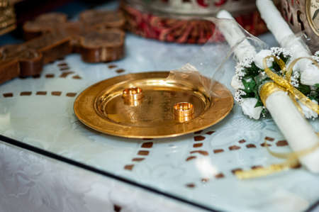 Gold wedding rings on the gold plate in the church