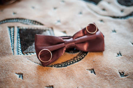 Pair of gold wedding rings on the red tiebowの写真素材