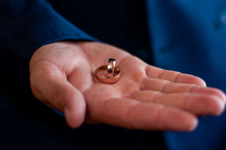 Pair of golden wedding rings on the handの写真素材