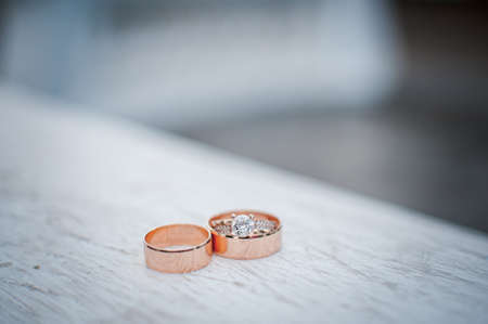 Pair of gold wedding rings on the white marbleの写真素材