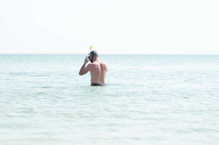 Man swimming with snorkeling mask in the ocean