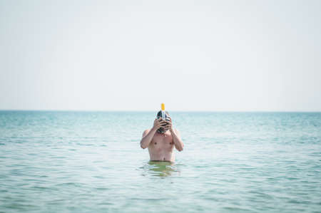 Man in swiming mask going on waterの写真素材