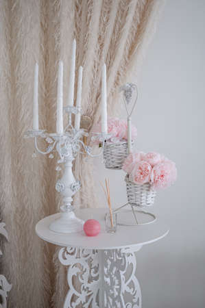 White table with candles and bouquet of flowersの写真素材