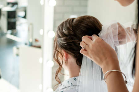 woman doing bride hairstyle with brown hair