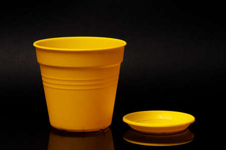 Yellow flower pot with stand on the black backgroundの写真素材