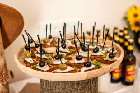 canapes on black bread with lard and olivesの写真素材