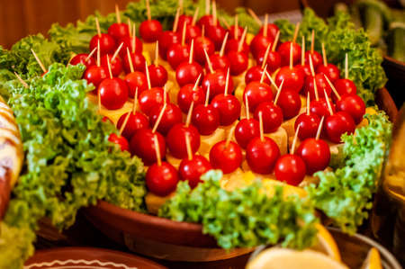 canape with cheese and cherry tomatoes, decorated with lettuce leavesの写真素材