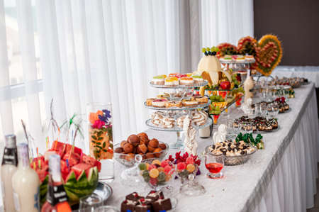 Sweet cakes in cups at a wedding buffet. Candy bar catering