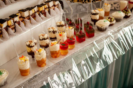 Sweet cakes in cups at a wedding buffet. Candy bar cateringの写真素材
