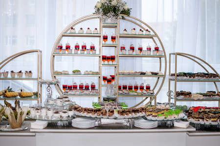 Sweet cakes in cups at a wedding buffet. Candy bar catering