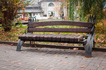 Wooden bench with a metal railing in the parkの写真素材