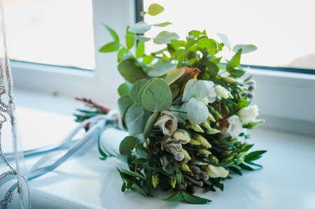 Bridal bouquet with white flowers and green branches on a white backgroundの写真素材