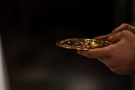 Wedding rings on a golden plateの写真素材