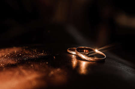 Wedding gold rings on brown backgroundの写真素材