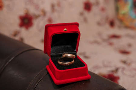 Pair of wedding rings in red box on brown backgroundの写真素材
