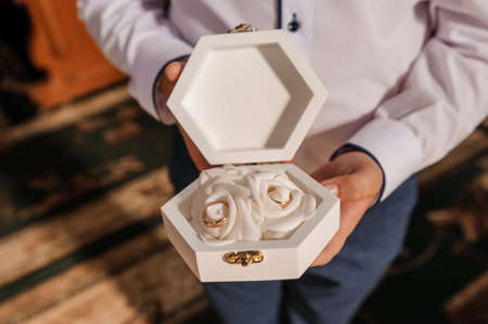 Wedding gold rings in a white box, wedding rings in hands