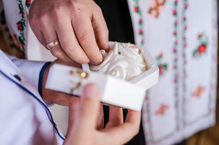 Wedding gold rings in a white box, wedding rings in handsの写真素材