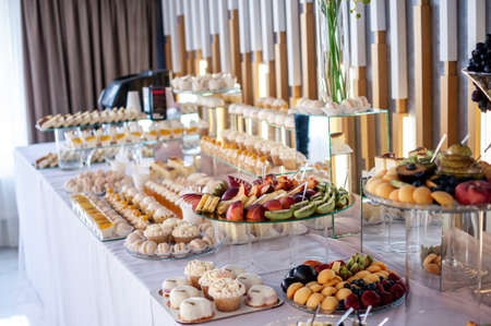 Sweet cakes at a wedding banquet. Catering, sweet festive buffet. Candy bar