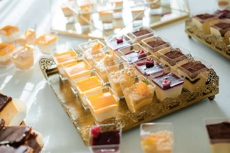 Sweet cakes at a wedding banquet. Catering, sweet festive buffet. Candy barの写真素材