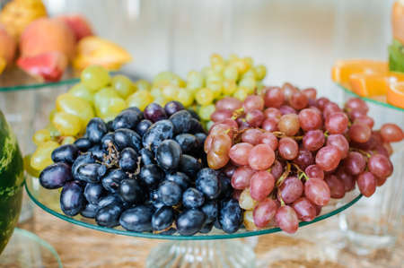 Fruit slicing at a wedding banquet. Watermelon, grapes, strawberry, orange, plum, pear, dinha, peach, kiwi, pineapple, persimmon, appleの写真素材