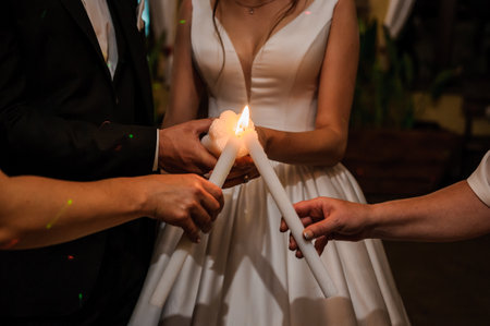Wedding traditions family lights. Candle in the hands of the newlywedsの写真素材