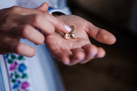 Earrings in the hands of the bride. Bridal wedding accessoriesの写真素材