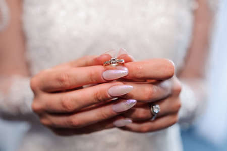 Gold ring with a stone in the hands of the brideの写真素材