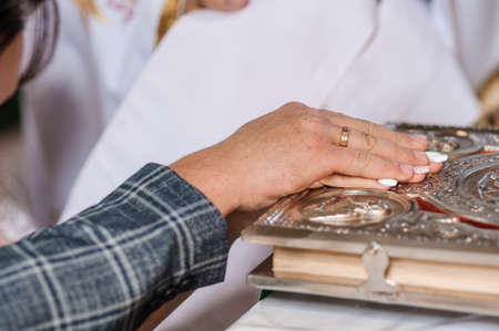 Hands of the bride and groom on the Bible. Church wedding ceremony