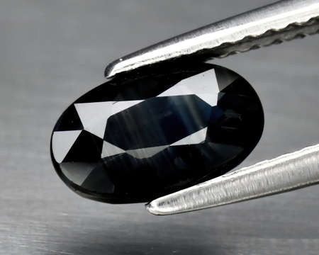 Natural gemstone blue sapphire on gray backgroundの写真素材