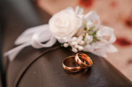 Pair of wedding rings and bouquet with white flowers