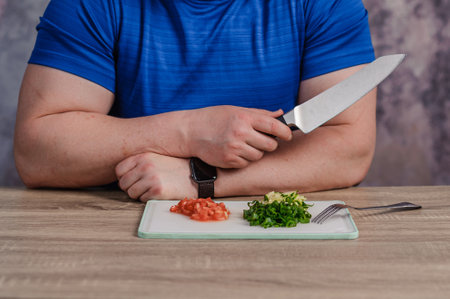 A man cuts green onions on a board. Healthy eatingの写真素材